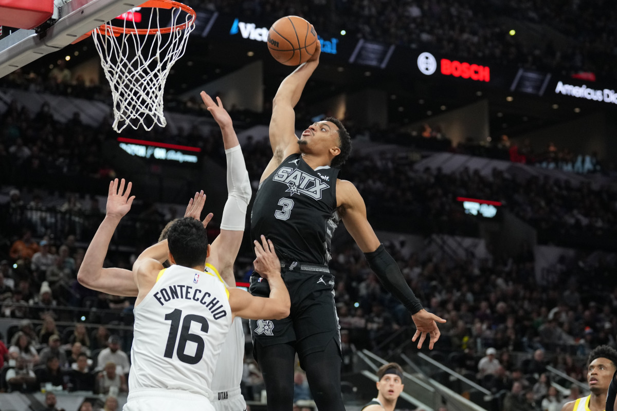 Dec 26, 2023; San Antonio, Texas, USA; San Antonio Spurs forward Keldon Johnson (3) dunks over Utah Jazz forward Simone Fontecchio (16) in the second half at Frost Bank Center.